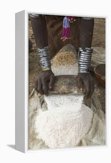 Africa, Ethiopia, Southern Omo, Karo Tribe. Woman grinding grain into flour with stone.-Ellen Goff-Framed Premier Image Canvas