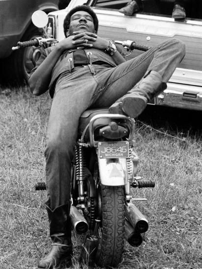 'African American Man Relaxing on His Motocycle During Motorcycle Races