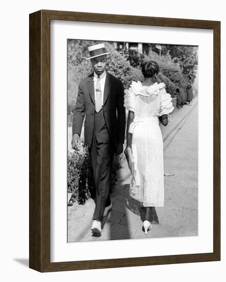 African American Sporting His Sunday Finery Glancing at Frilly Frocked Girl Passing Him on Street-Alfred Eisenstaedt-Framed Photographic Print