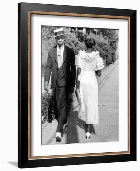 African American Sporting His Sunday Finery Glancing at Frilly Frocked Girl Passing Him on Street-Alfred Eisenstaedt-Framed Photographic Print