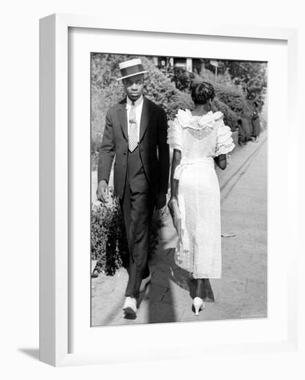 African American Sporting His Sunday Finery Glancing at Frilly Frocked Girl Passing Him on Street-Alfred Eisenstaedt-Framed Photographic Print