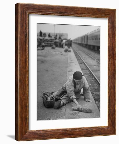 Aged Refugee Fighting Hunger, Sweeps Up Spilled Rice on the Railroad Station Platform-Jack Birns-Framed Photographic Print