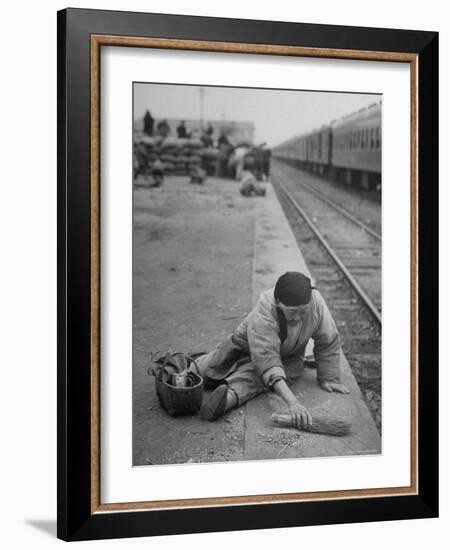 Aged Refugee Fighting Hunger, Sweeps Up Spilled Rice on the Railroad Station Platform-Jack Birns-Framed Photographic Print