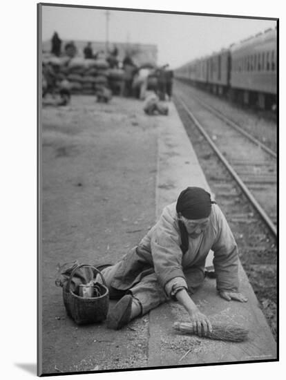 Aged Refugee Fighting Hunger, Sweeps Up Spilled Rice on the Railroad Station Platform-Jack Birns-Mounted Photographic Print