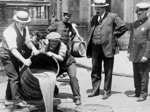 Agents pour liquor into sewer following a raid during the height of prohibition, New York, 1921