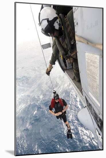 Aircrewman Assists in Hoisting a Member into an Mh-60S Sea Hawk-null-Mounted Photographic Print
