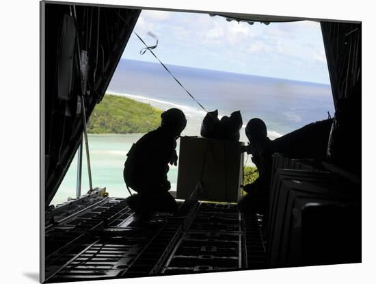 Airmen Push Out a Pallet of Donated Goods from a C-130 Hercules-Stocktrek Images-Mounted Photographic Print