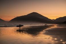 A Surfer Makes His Way Out of the Water at Sunset on Praia Do Itamambuca in Brazil-Alex Saberi-Photographic Print