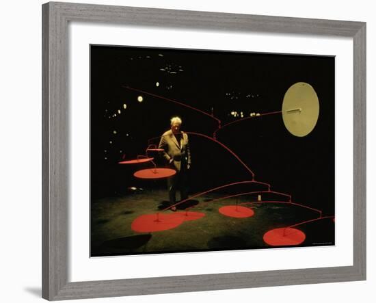 Alexander Calder Walking Past Exhibit of His Mobiles at the Guggenheim Museum-Gjon Mili-Framed Premium Photographic Print