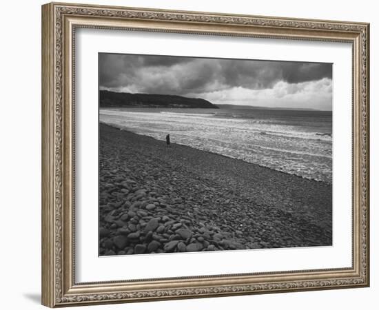 Along British Coastline, Woman Walking on Pebbled Shore-Nat Farbman-Framed Photographic Print