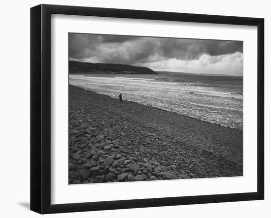 Along British Coastline, Woman Walking on Pebbled Shore-Nat Farbman-Framed Photographic Print