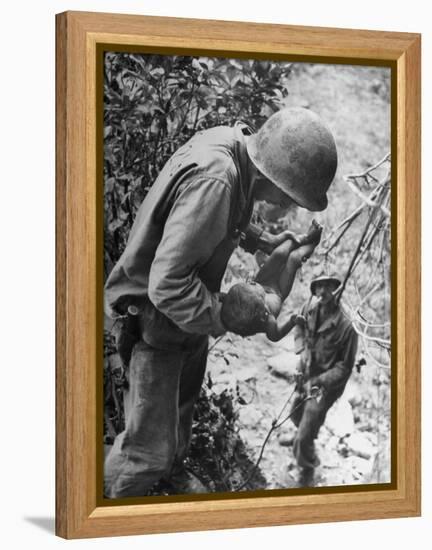 American Lieutenant Carrying Micronesian Baby He Found in cave Japanese Soldiers Holed Up There-W^ Eugene Smith-Framed Premier Image Canvas