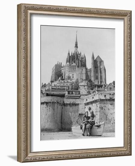 American Travelers Below France's Medieval Abbey at Mont Saint Michel Reading Together from a Book-Yale Joel-Framed Photographic Print