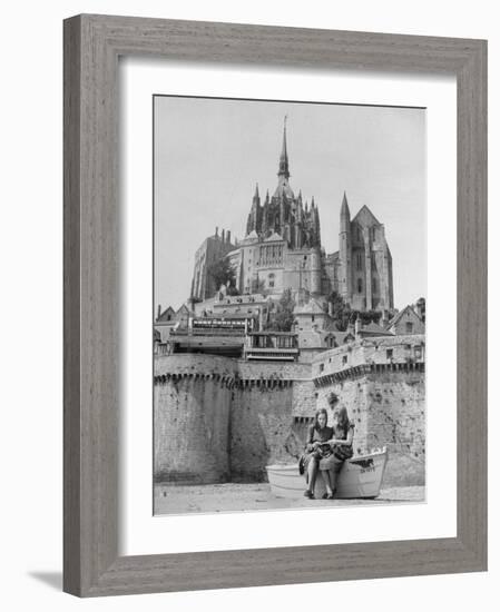 American Travelers Below France's Medieval Abbey at Mont Saint Michel Reading Together from a Book-Yale Joel-Framed Photographic Print