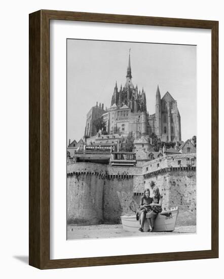 American Travelers Below France's Medieval Abbey at Mont Saint Michel Reading Together from a Book-Yale Joel-Framed Photographic Print