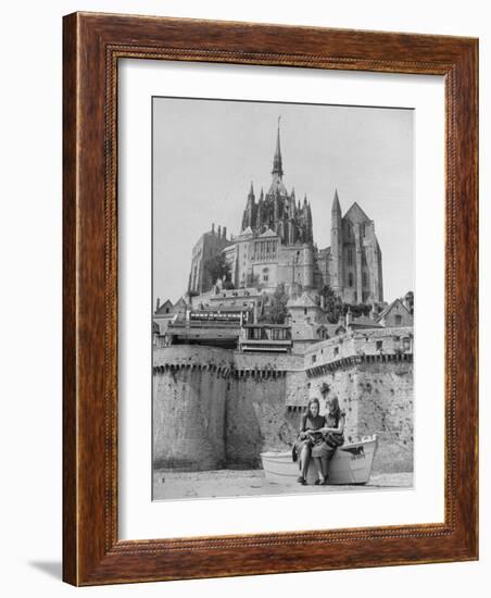 American Travelers Below France's Medieval Abbey at Mont Saint Michel Reading Together from a Book-Yale Joel-Framed Photographic Print