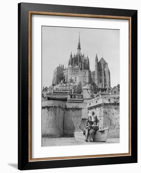 American Travelers Below France's Medieval Abbey at Mont Saint Michel Reading Together from a Book-Yale Joel-Framed Photographic Print