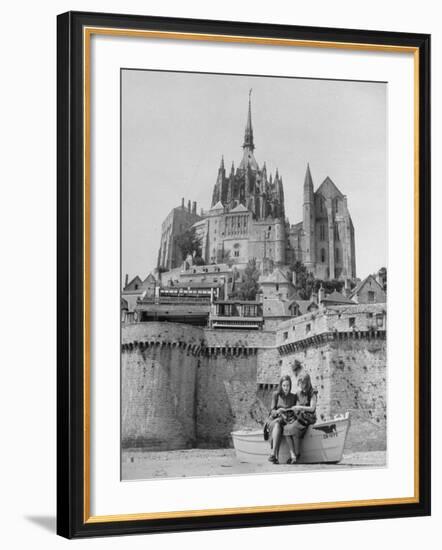 American Travelers Below France's Medieval Abbey at Mont Saint Michel Reading Together from a Book-Yale Joel-Framed Photographic Print