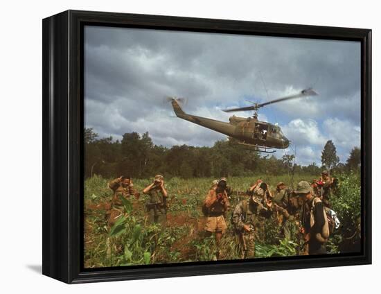 American UH1 Huey Helicopter Lifting Off as Personnel on the Ground Protect Themselves-Larry Burrows-Framed Premier Image Canvas