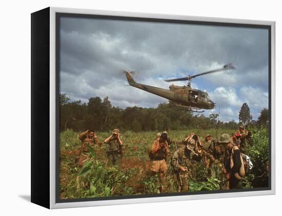 American UH1 Huey Helicopter Lifting Off as Personnel on the Ground Protect Themselves-Larry Burrows-Framed Premier Image Canvas