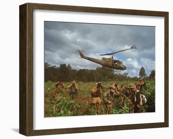 American UH1 Huey Helicopter Lifting Off as Personnel on the Ground Protect Themselves-Larry Burrows-Framed Photographic Print