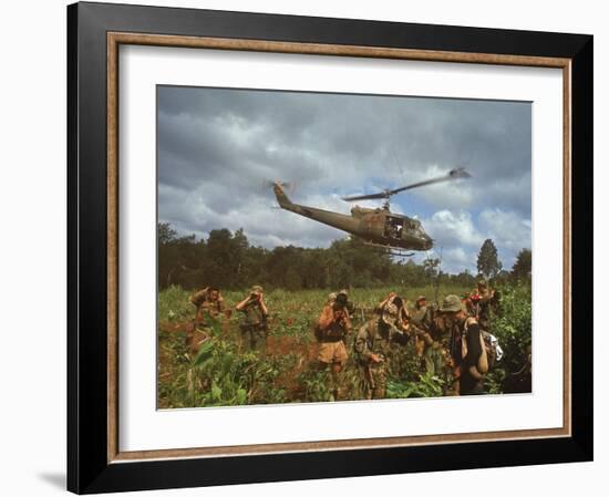 American UH1 Huey Helicopter Lifting Off as Personnel on the Ground Protect Themselves-Larry Burrows-Framed Photographic Print