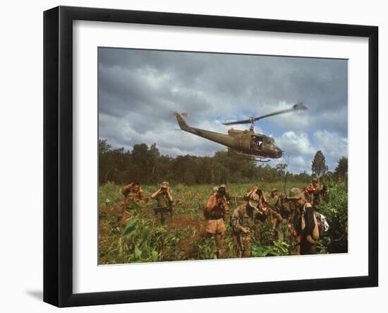 American UH1 Huey Helicopter Lifting Off as Personnel on the Ground Protect Themselves-Larry Burrows-Framed Photographic Print