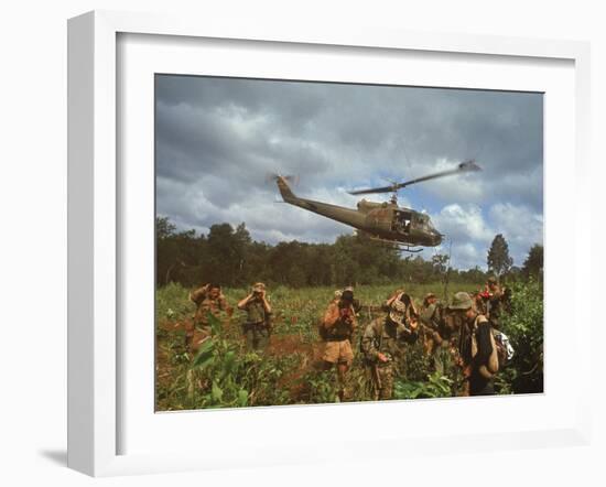 American UH1 Huey Helicopter Lifting Off as Personnel on the Ground Protect Themselves-Larry Burrows-Framed Photographic Print