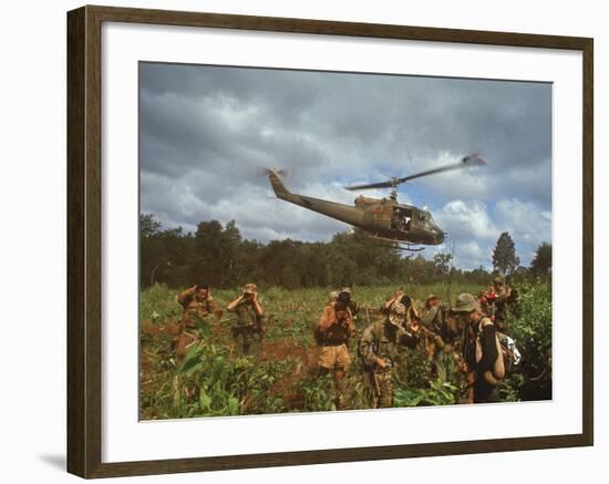 American UH1 Huey Helicopter Lifting Off as Personnel on the Ground Protect Themselves-Larry Burrows-Framed Photographic Print
