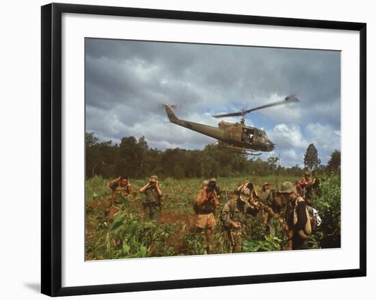 American UH1 Huey Helicopter Lifting Off as Personnel on the Ground Protect Themselves-Larry Burrows-Framed Photographic Print