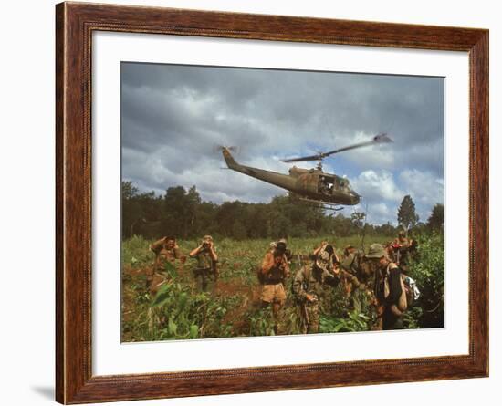 American UH1 Huey Helicopter Lifting Off as Personnel on the Ground Protect Themselves-Larry Burrows-Framed Photographic Print