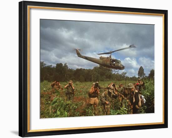 American UH1 Huey Helicopter Lifting Off as Personnel on the Ground Protect Themselves-Larry Burrows-Framed Photographic Print