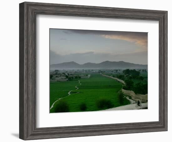 An Afghan Man Rides His Bicycle on a Dirt Road on the Northern Edge of Kabul, Afghanistan-David Guttenfelder-Framed Photographic Print