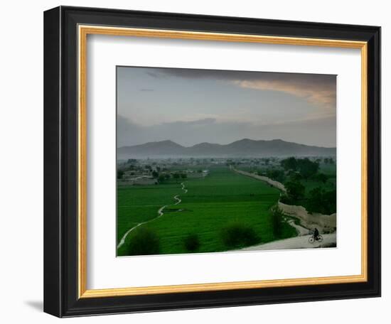 An Afghan Man Rides His Bicycle on a Dirt Road on the Northern Edge of Kabul, Afghanistan-David Guttenfelder-Framed Photographic Print