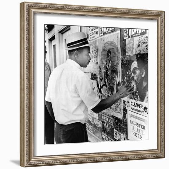 An African American Pokes His Finger into a Bullet Hole in the Oakland Black Panther's Headquarters-null-Framed Photo