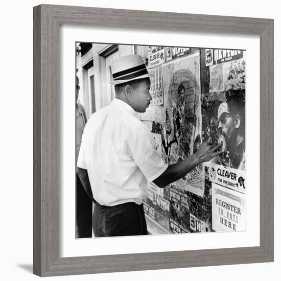 An African American Pokes His Finger into a Bullet Hole in the Oakland Black Panther's Headquarters-null-Framed Photo