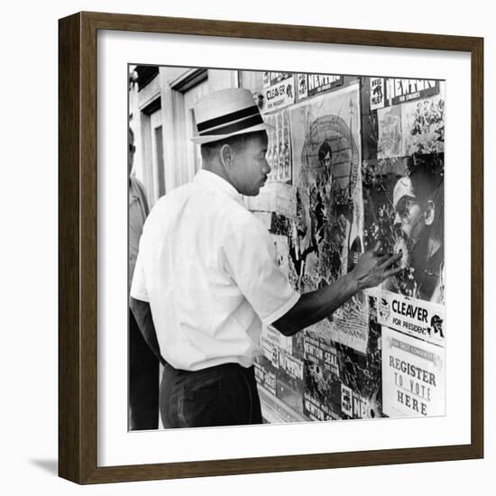 An African American Pokes His Finger into a Bullet Hole in the Oakland Black Panther's Headquarters-null-Framed Photo