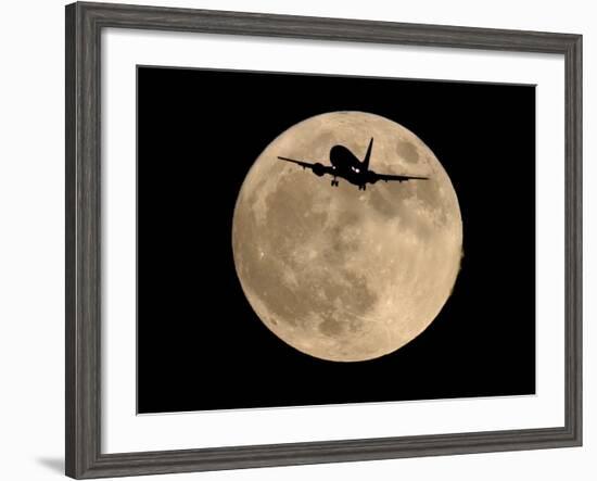 An Airliner is Silhouetted against a Full Moon-null-Framed Photographic Print