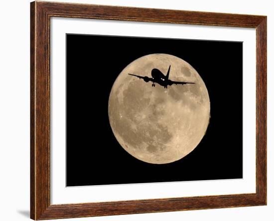 An Airliner is Silhouetted against a Full Moon-null-Framed Photographic Print