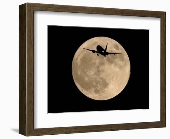 An Airliner is Silhouetted against a Full Moon-null-Framed Photographic Print