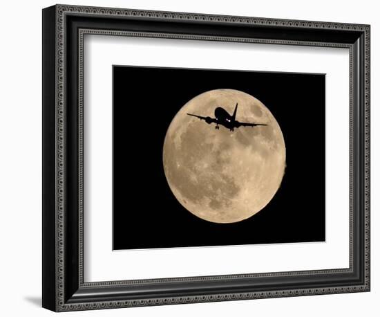 An Airliner is Silhouetted against a Full Moon-null-Framed Photographic Print