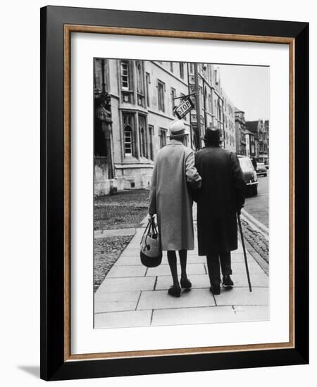 An Elderly Couple Walking Down the Street, Arm in Arm-Henry Grant-Framed Photographic Print