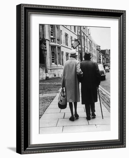 An Elderly Couple Walking Down the Street, Arm in Arm-Henry Grant-Framed Photographic Print