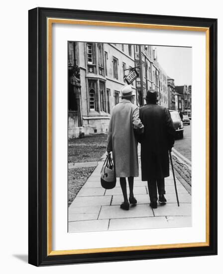 An Elderly Couple Walking Down the Street, Arm in Arm-Henry Grant-Framed Photographic Print