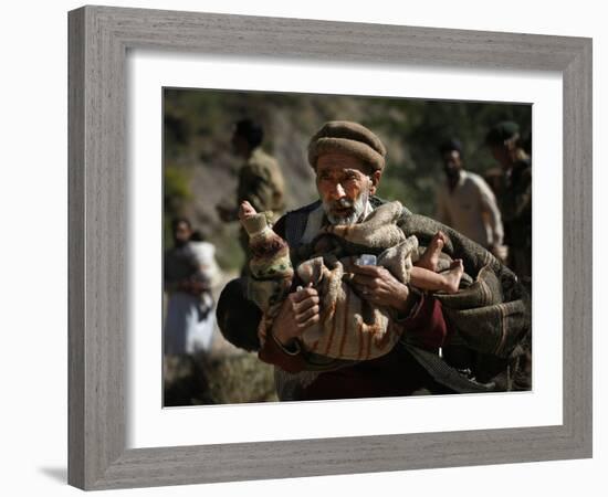 An Elderly Pakistani Earthquake Survivor Rushes Towards a Helicopter Carrying a Child in His Arms-null-Framed Photographic Print