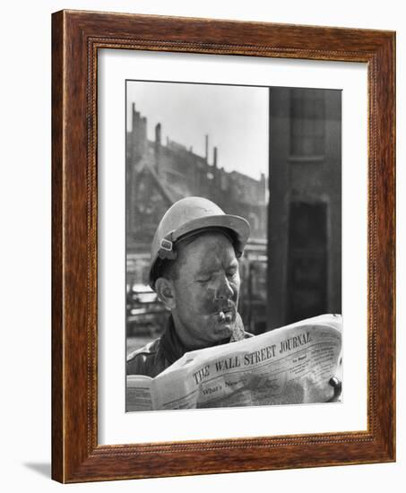 An Electrician Reads 'The Wall Street Journal' to Check His Stock Market Investments-null-Framed Photo