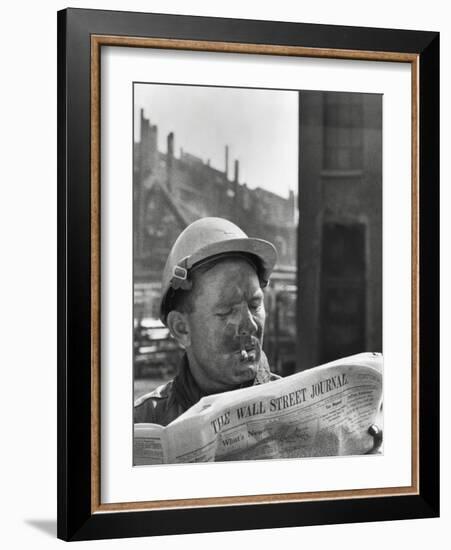 An Electrician Reads 'The Wall Street Journal' to Check His Stock Market Investments-null-Framed Photo