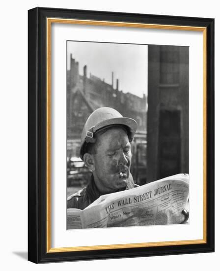 An Electrician Reads 'The Wall Street Journal' to Check His Stock Market Investments-null-Framed Photo