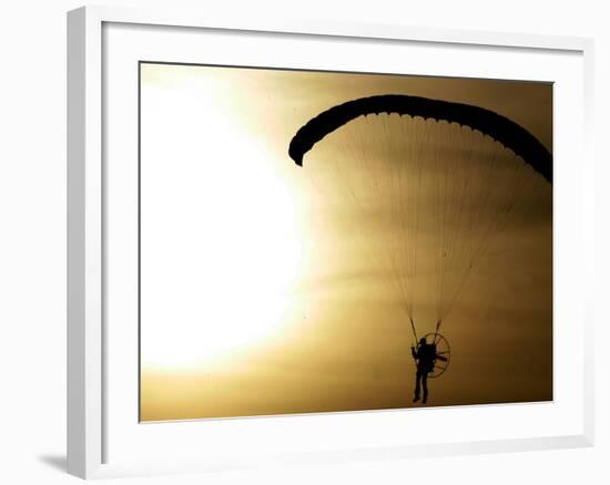 An Engine-Powered Paraglider Soars Through the Air Near Schlesen-null-Framed Photographic Print