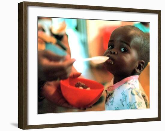 An Unidentified Baby is Fed at a Home for Hiv/Aids and Abandoned Children-null-Framed Photographic Print